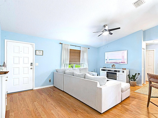 222 SW Starfish Ave, Port Saint Lucie, FL 34984 - living room featuring vaulted ceiling, light wood-type flooring, ceiling fan, baseboards, and a fireplace