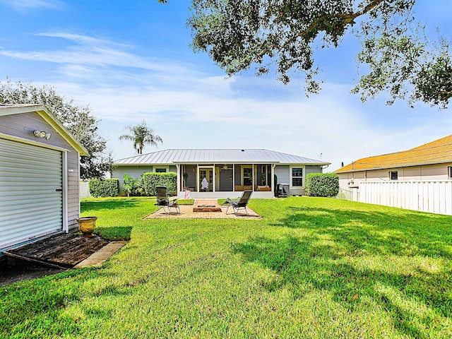 back of house featuring a yard, a fire pit, and a patio