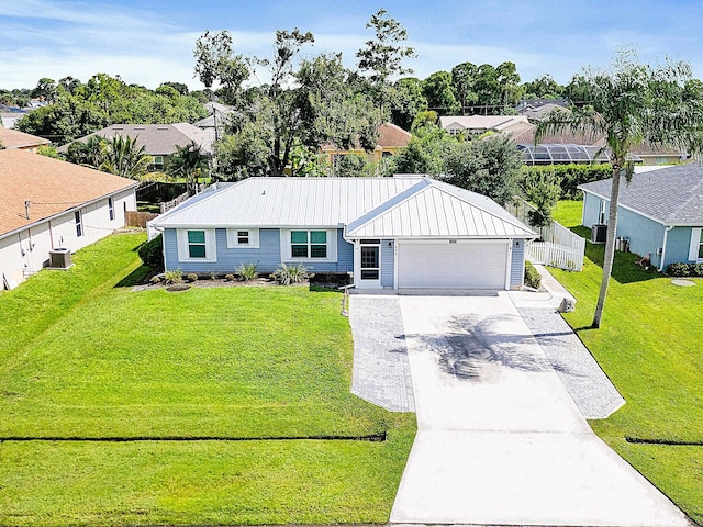 ranch-style home featuring central AC, a garage, and a front lawn