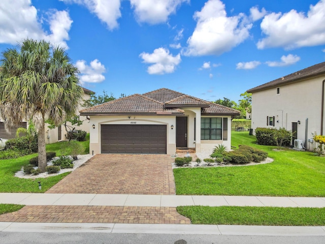 mediterranean / spanish house featuring a front yard and a garage