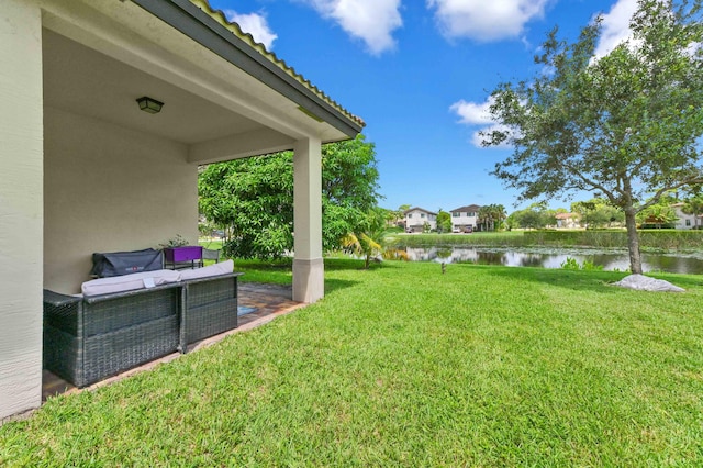 view of yard featuring a water view and a patio