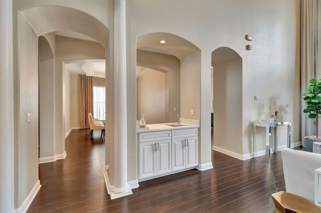 16106 Rosecroft Ter, Delray Beach, FL 33446 - hall featuring arched walkways, a sink, dark wood-style floors, and baseboards