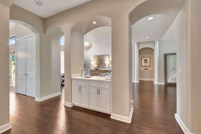 16106 Rosecroft Ter, Delray Beach, FL 33446 - hallway with arched walkways, visible vents, a sink, and dark wood-style floors