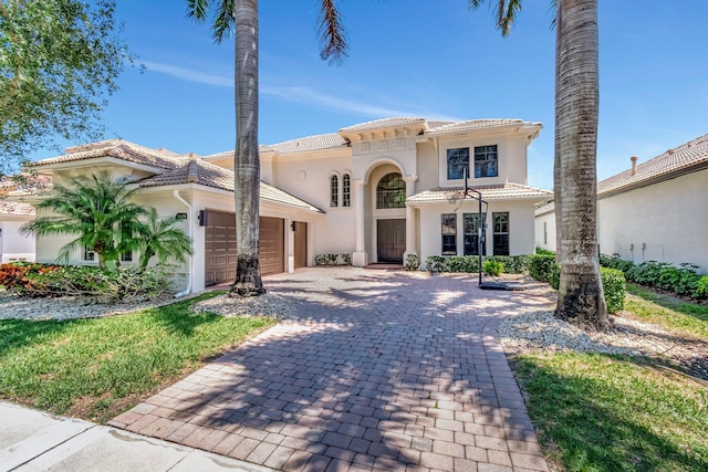 16106 Rosecroft Ter, Delray Beach, FL 33446 - mediterranean / spanish-style home with stucco siding, a tiled roof, decorative driveway, and an attached garage