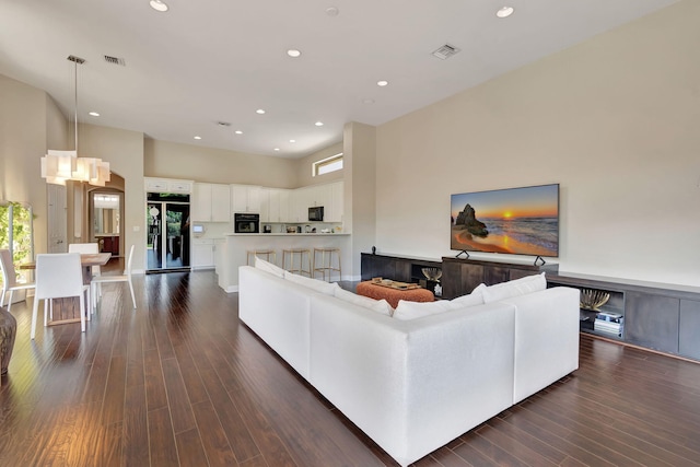 living room featuring dark hardwood / wood-style floors and an inviting chandelier