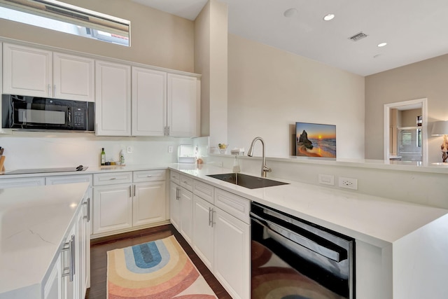 kitchen with black appliances, light stone countertops, dark hardwood / wood-style flooring, and sink