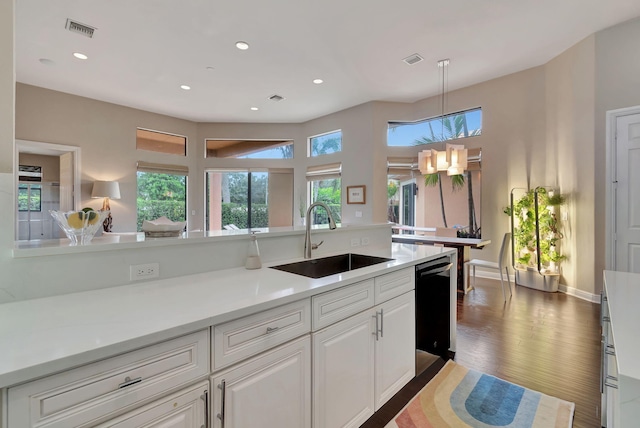 kitchen with hardwood / wood-style flooring, a wealth of natural light, sink, and white cabinets