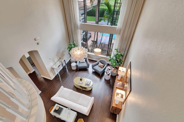 16106 Rosecroft Ter, Delray Beach, FL 33446 - living area with baseboards, arched walkways, a high ceiling, a textured wall, and wood finished floors