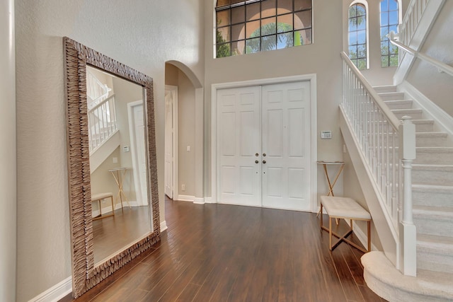 16106 Rosecroft Ter, Delray Beach, FL 33446 - foyer entrance with baseboards, arched walkways, dark wood finished floors, stairway, and a towering ceiling