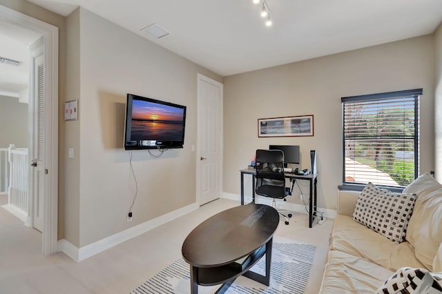 carpeted living room featuring track lighting