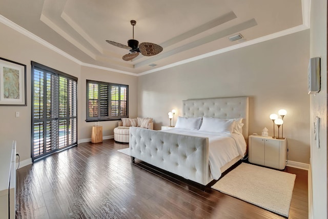 bedroom featuring a tray ceiling, dark hardwood / wood-style flooring, ornamental molding, and ceiling fan