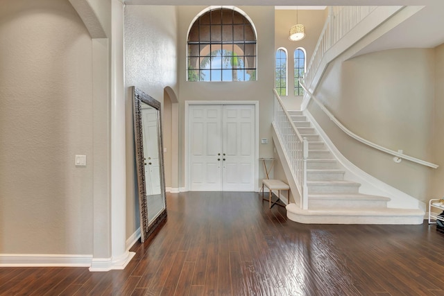 16106 Rosecroft Ter, Delray Beach, FL 33446 - entrance foyer featuring baseboards, a textured wall, stairs, arched walkways, and wood-type flooring