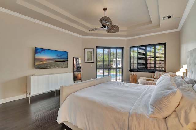 bedroom featuring crown molding, a raised ceiling, radiator heating unit, and dark wood-type flooring