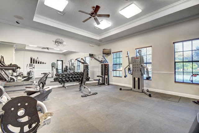 gym featuring ceiling fan, a raised ceiling, crown molding, and a textured ceiling