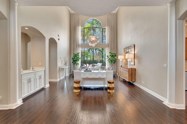 16106 Rosecroft Ter, Delray Beach, FL 33446 - entrance foyer featuring arched walkways, a towering ceiling, baseboards, and dark wood-style floors