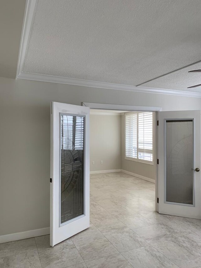 empty room with ceiling fan, crown molding, and a textured ceiling