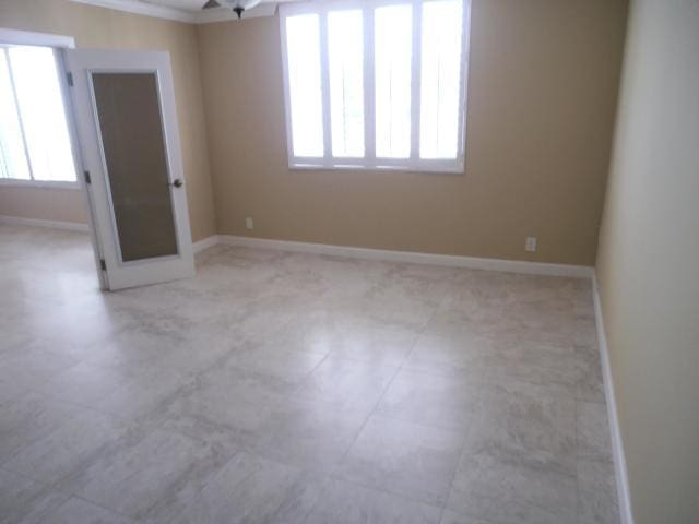 empty room with plenty of natural light and crown molding