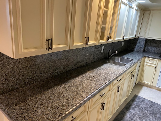 kitchen featuring light tile patterned floors, tasteful backsplash, sink, and cream cabinetry