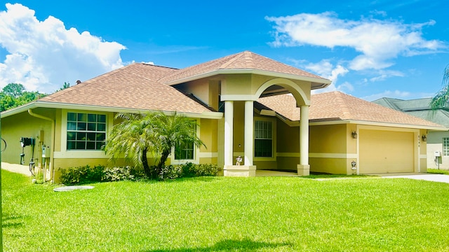 mediterranean / spanish-style home with a front yard and a garage