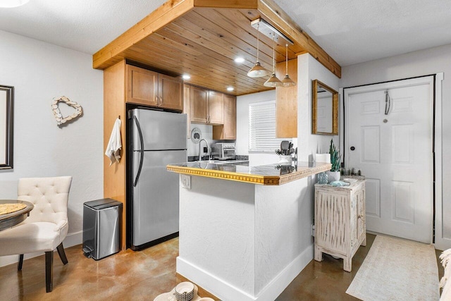 kitchen featuring wood ceiling, stainless steel fridge, kitchen peninsula, pendant lighting, and a textured ceiling