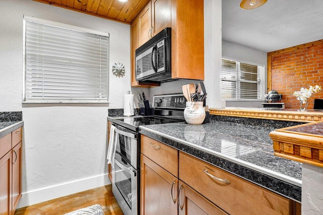 kitchen with stainless steel electric range, a textured ceiling, and light hardwood / wood-style flooring