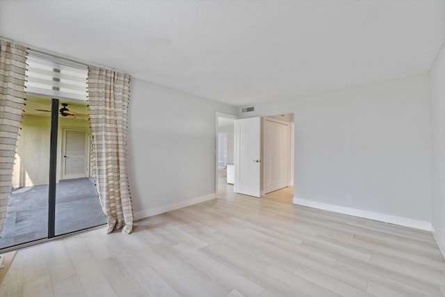 unfurnished room with a textured ceiling, light hardwood / wood-style flooring, and ceiling fan