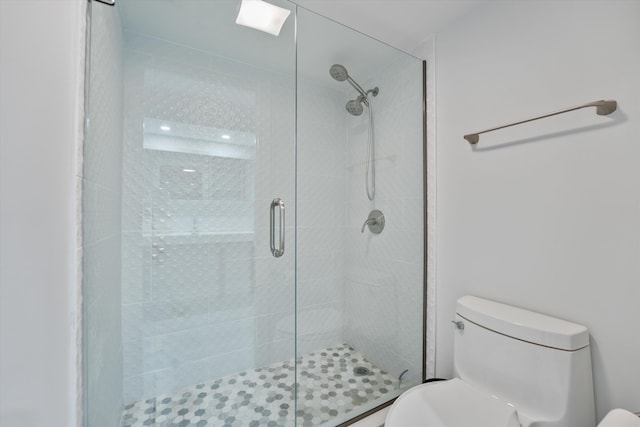 bathroom featuring toilet and a shower with door