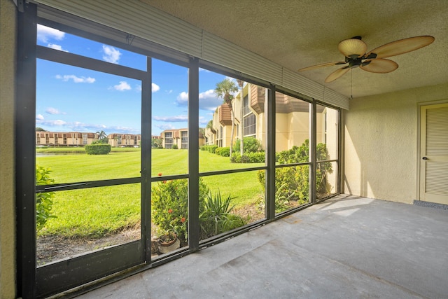 unfurnished sunroom with ceiling fan