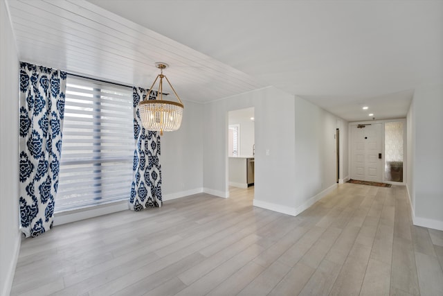 interior space featuring light wood-type flooring and an inviting chandelier