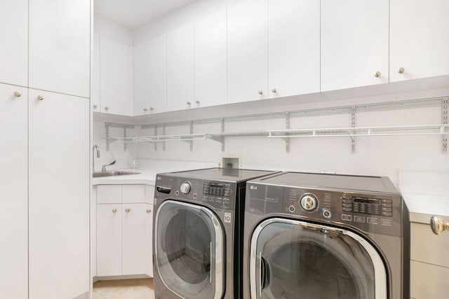 clothes washing area featuring cabinets, washer and dryer, and sink