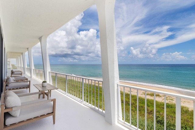 balcony featuring a water view and a beach view