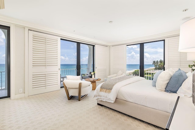 bedroom featuring a water view, access to exterior, french doors, and crown molding