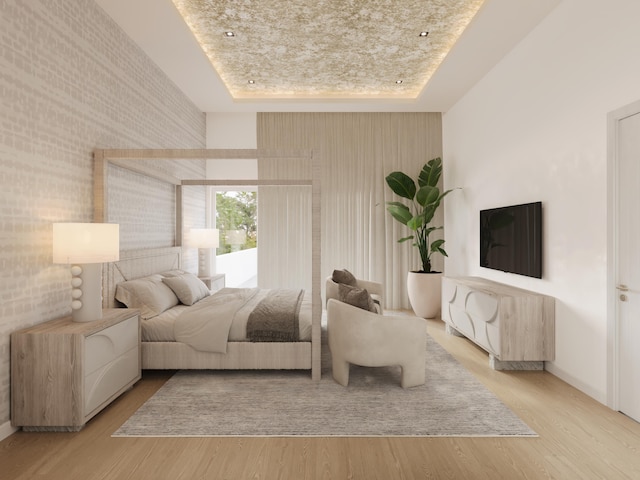 bedroom with a tray ceiling, baseboards, and wood finished floors