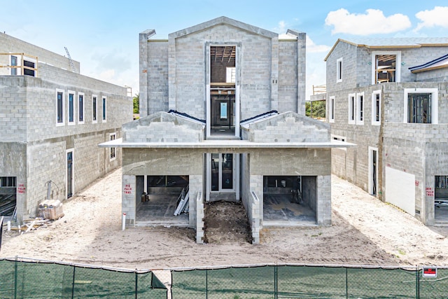 rear view of house featuring a garage, fence, and a multi sided fireplace