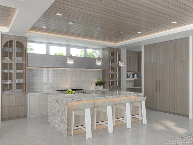 kitchen with a tray ceiling, modern cabinets, and a breakfast bar area