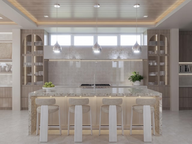 kitchen with a tray ceiling, glass insert cabinets, and tasteful backsplash