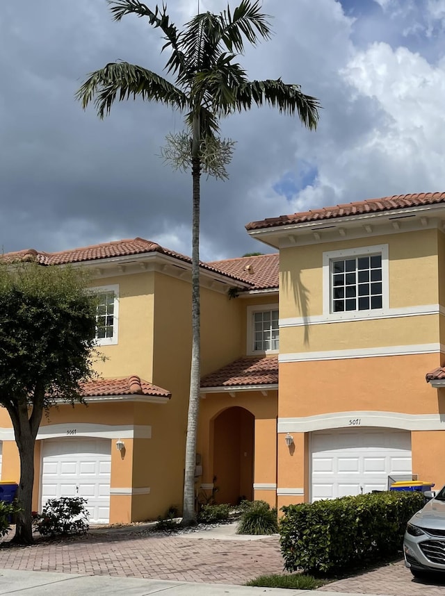 5071 SE Mariner Garden Cir, Stuart, FL 34997 - mediterranean / spanish home featuring a tiled roof, stucco siding, decorative driveway, and a garage