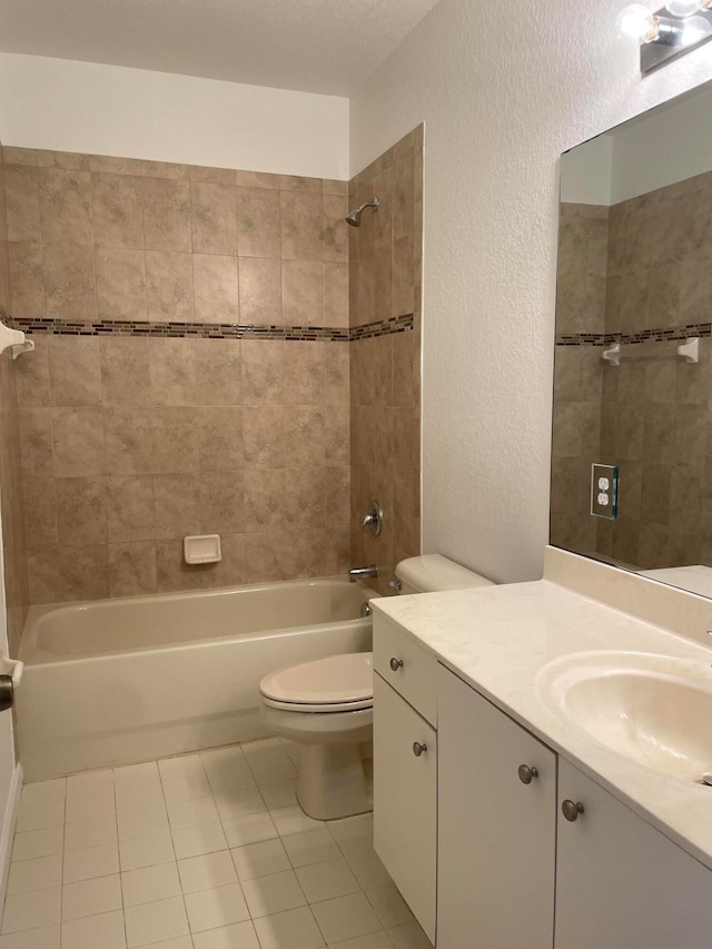 full bathroom featuring toilet, vanity, tile patterned floors, and tiled shower / bath