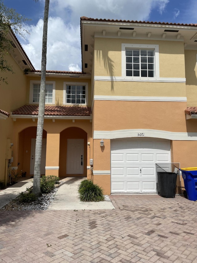 5071 SE Mariner Garden Cir, Stuart, FL 34997 - view of front of house featuring stucco siding, a tiled roof, an attached garage, and decorative driveway