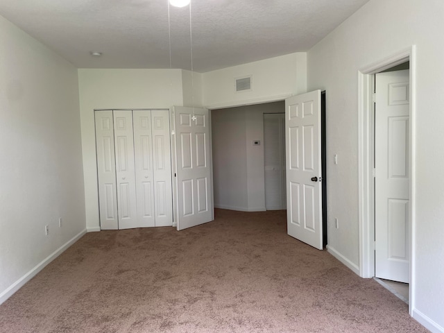 unfurnished bedroom featuring carpet flooring and a textured ceiling