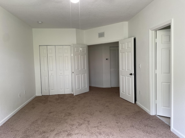 5071 SE Mariner Garden Cir, Stuart, FL 34997 - unfurnished bedroom featuring a closet, a textured ceiling, visible vents, carpet flooring, and baseboards