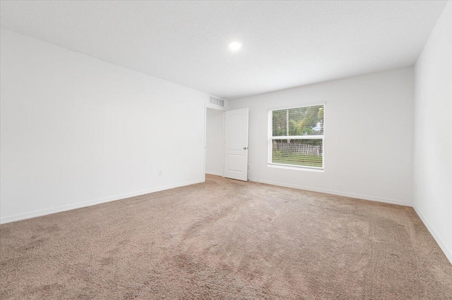 unfurnished room with a textured ceiling and carpet flooring