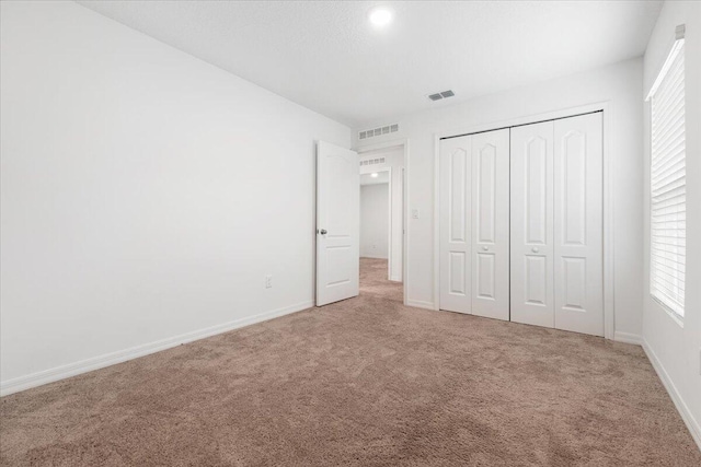 unfurnished bedroom with carpet flooring and a closet