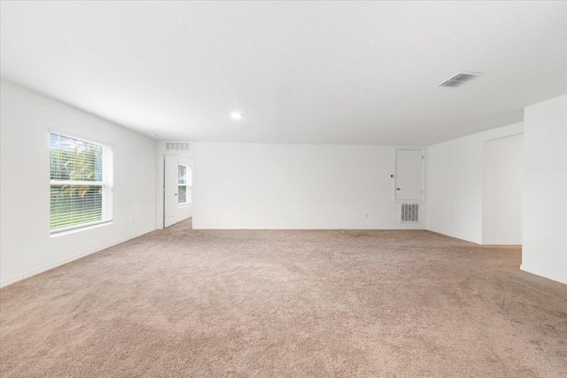 empty room featuring light colored carpet and a textured ceiling