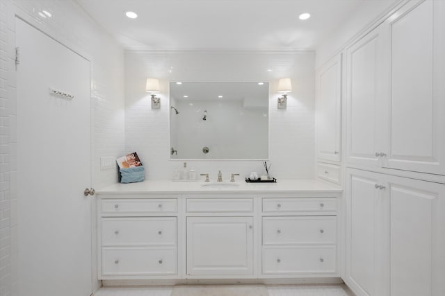 bathroom featuring a tile shower and vanity