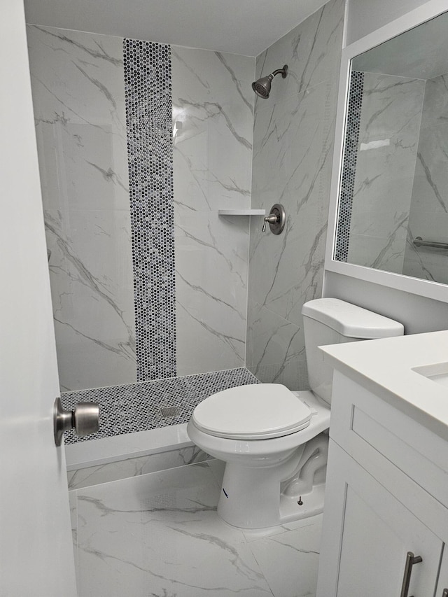 bathroom featuring tiled shower, vanity, and toilet