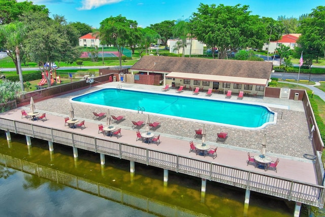 view of pool featuring a patio area and a water view