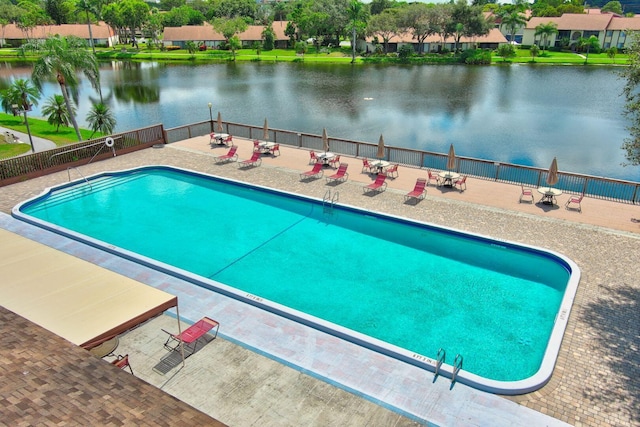 view of swimming pool featuring a patio and a water view