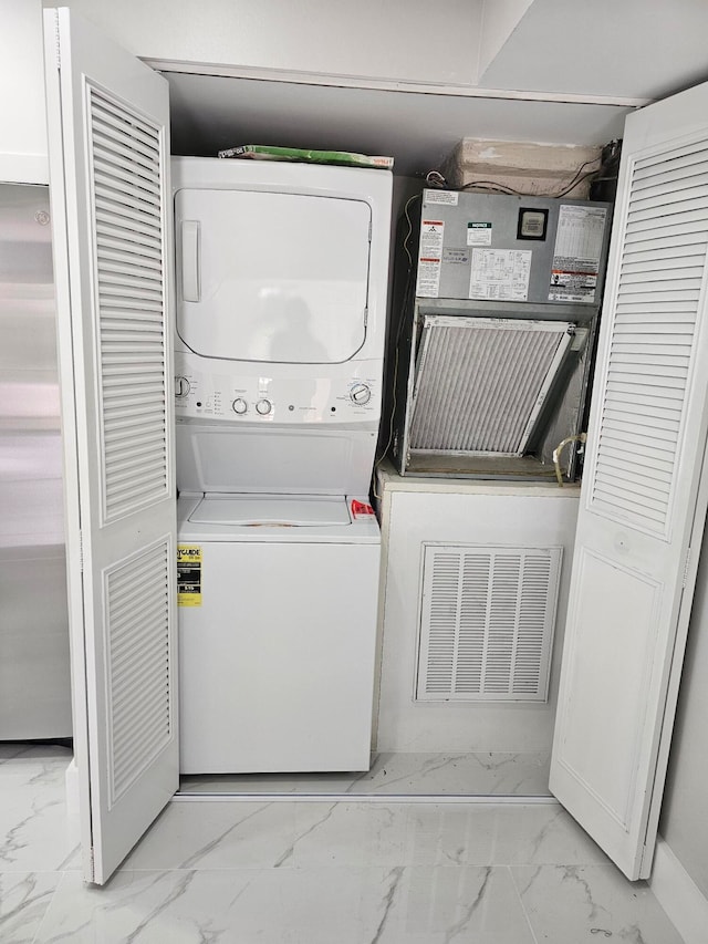 clothes washing area with stacked washer / dryer