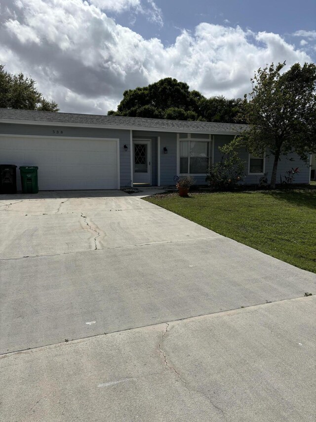 ranch-style home featuring a garage and a front lawn